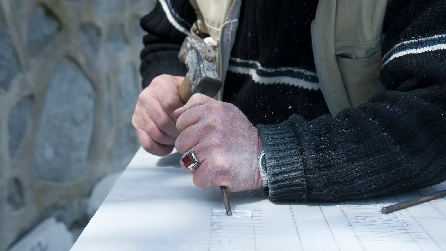 A Da Vinci craftsman hand-carving a granite monument